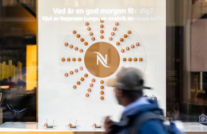 Förbpaserande tittar på skyltfönsterdesignen av WorkShop i Nespresso Store på Kungsgatan.